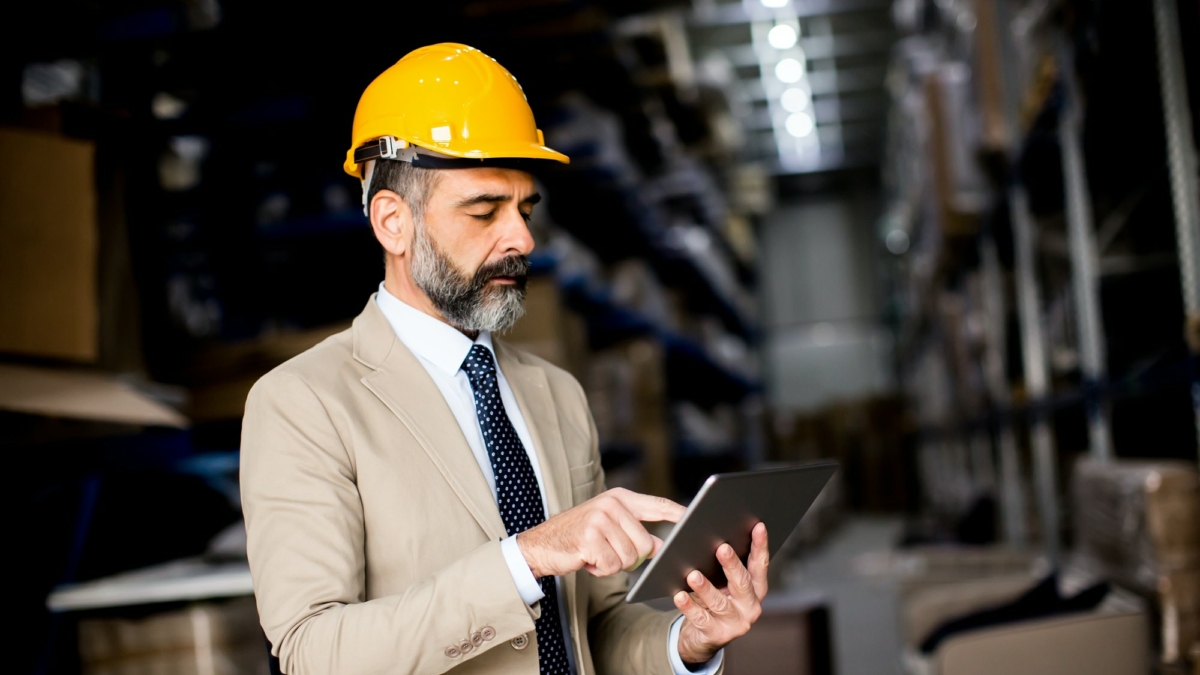 Middle-aged businessman with digital tablet in factory
