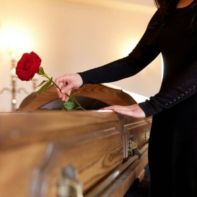 woman-with-red-roses-and-coffin-at-funeral-1024x682